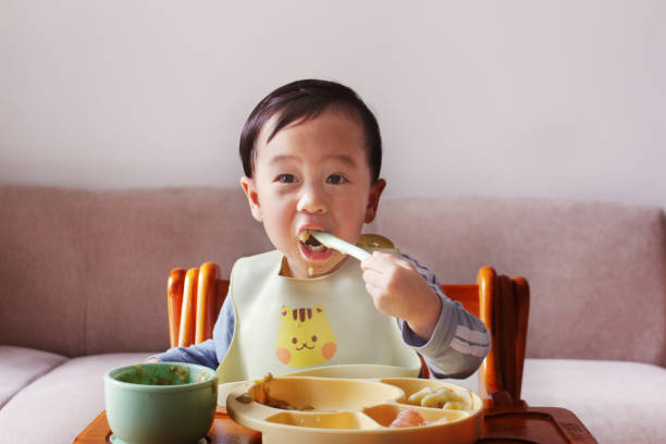 istock An cute Asian baby eating on a chair 2202805942