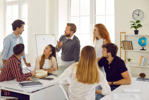 istock Creative friendly male teacher talks and discusses with students subject of educational lesson. 2202810214