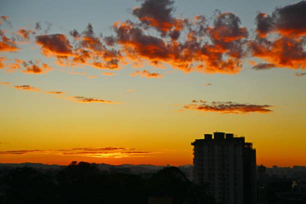 Buildingcsilhouette, clouds in golden sky, red, orange and yellow horizon