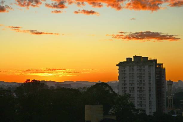 Town buildings, horizon with sun raising, silhouettes and shadows over the city