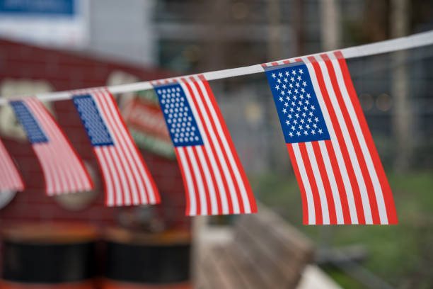 Paris,France-09.02.2025 Colorful miniature American flags flutter gently in the breeze, adding a festive touch to a park gathering, reflecting a spirit of celebration and unity.