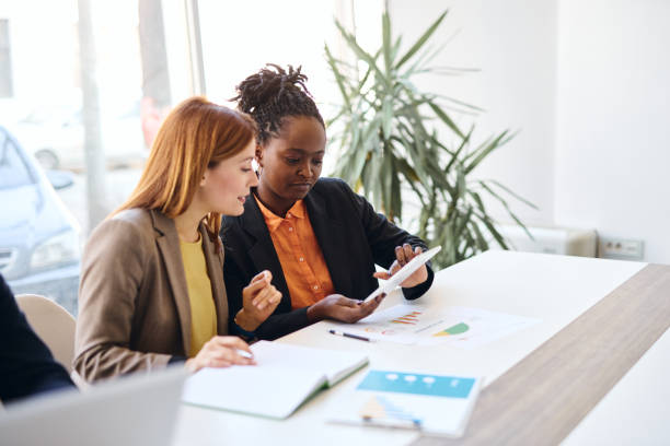 istock Businesswomen using tablet and analyzing financial data in modern office 2202814223
