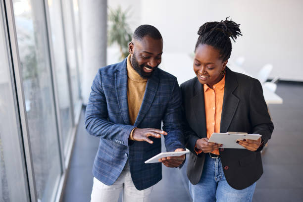 istock Business partners using tablet and clipboard walking in modern office 2202814337