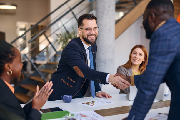istock Business partners shaking hands after successful meeting in modern office 2202814370