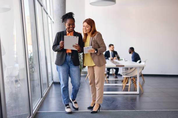 istock Businesswomen discussing using tablet and clipboard in modern office 2202814526