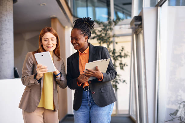 istock Two businesswomen looking at digital tablet in modern office 2202814549