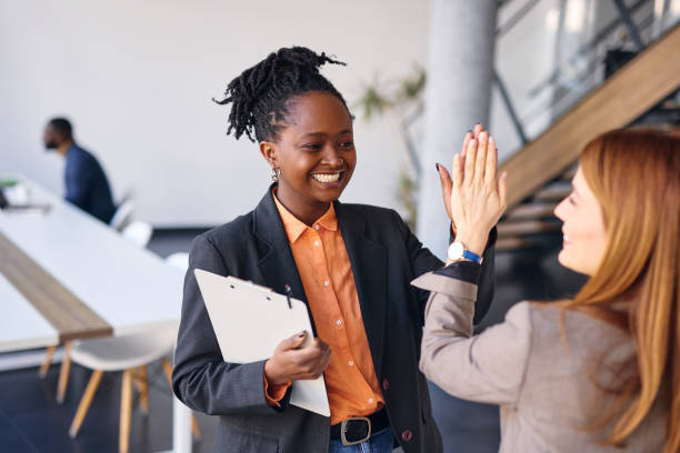 istock Two happy businesswomen giving high five in modern office 2202814551