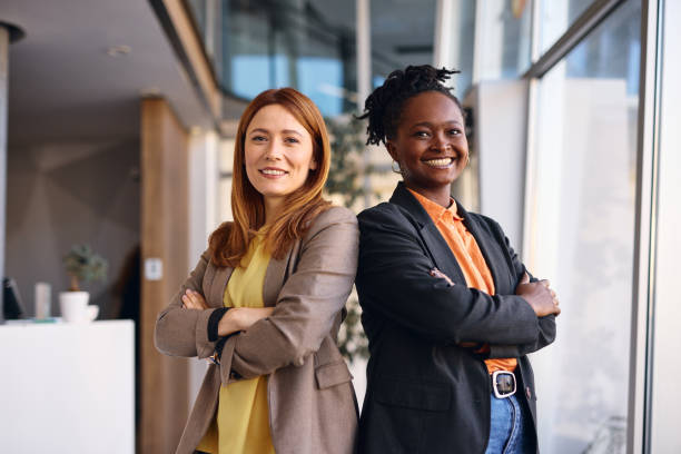 istock Two businesswomen standing back to back in modern office 2202814571