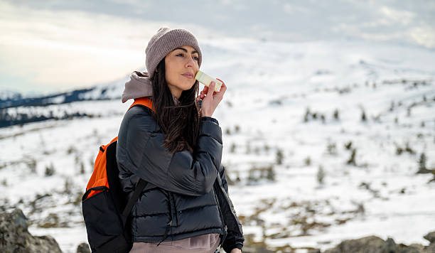 istock Woman applying spf sun stick in the winter mountain 2202816082