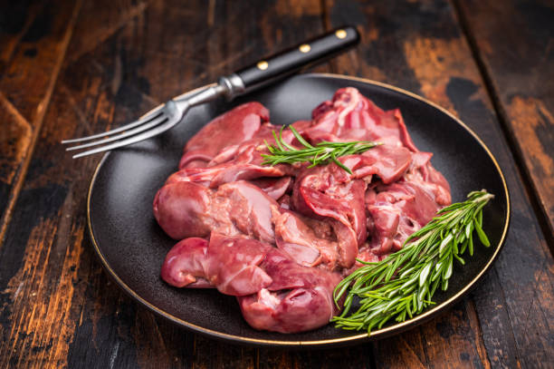 istock Raw chicken liver, featuring a glossy sheen and rich hue. A versatile ingredient that brings bold flavors to any culinary creation. wooden background. top view 2202817642