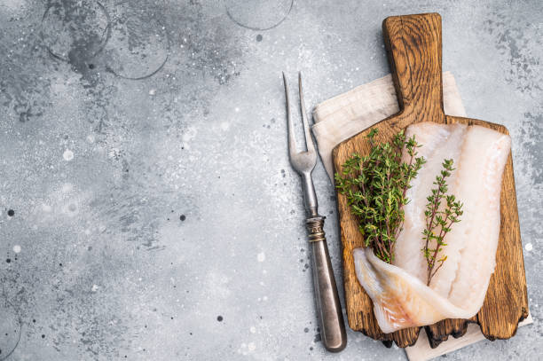 istock Fresh cod fish fillet, showcasing its delicate texture and pristine color, perfect for grilling or baking. grey background. top view 2202817716
