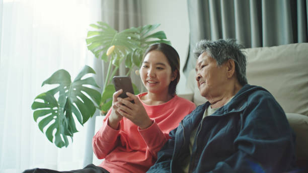 istock Elderly relax watching on a smartphone with her granddaughter. 2202817915