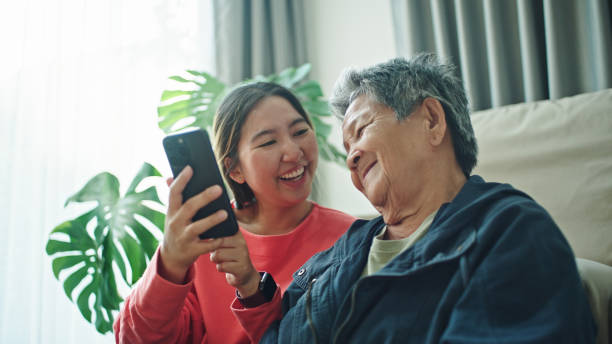 istock Elderly relax watching on a smartphone with her granddaughter. 2202817927