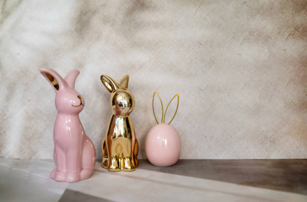 istock Pink and golden Ceramic Easter eggs and bunny on shadows background 2202818260