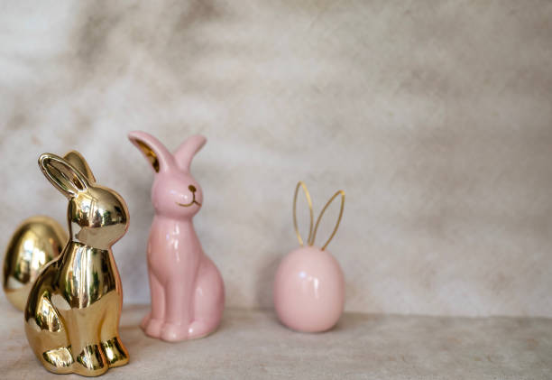 istock Pink and golden Ceramic Easter eggs and bunny on shadows background 2202818277