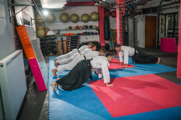 istock Aikido master shows exercises to a group of young fighters. They do push-ups 2202818501
