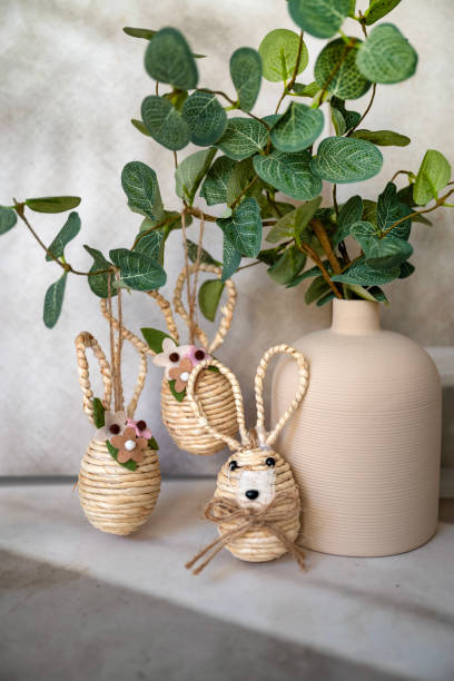 istock Easter decoration with green plant in vase and golden easter eggs and easter bunny 2202818825
