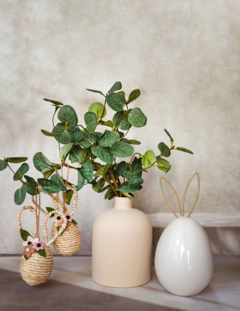 istock Easter decoration with green plant in vase and golden easter eggs and easter bunny 2202818871