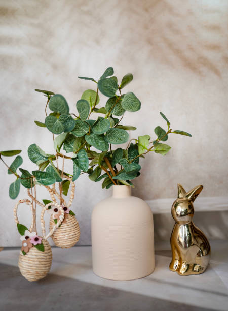 istock Easter decoration with green plant in vase and golden easter eggs and easter bunny 2202818976