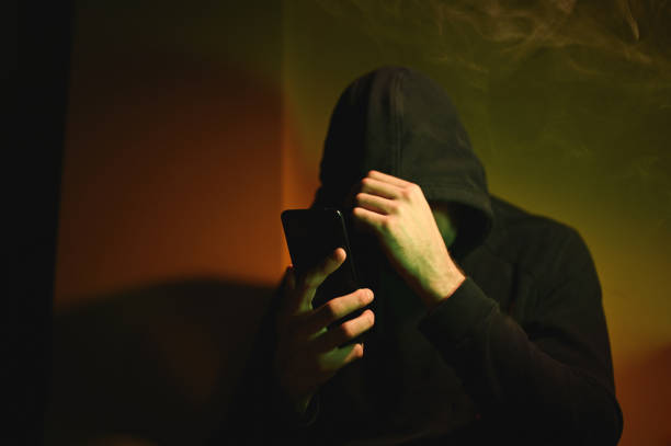 istock Hiding Hacker in hood at darkroom. 2202824695