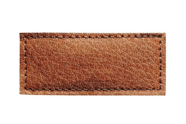 istock Brown leather belt strap closeup isolated on white. Brown stitched leather seam frame label tag isolated on white. Sewing background. 2202825188