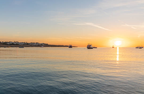 Sunrise over the sea. Panoramic seascape. Burning sky and shining golden waves. Sun over sea