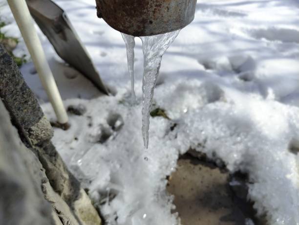 istock Icicle hangs under a drainpipe of a house 2202829855