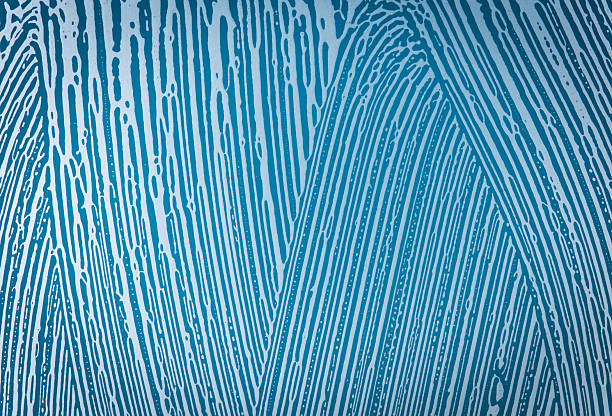 soap foam on window glass, blue background, spring cleaning, abstract pattern