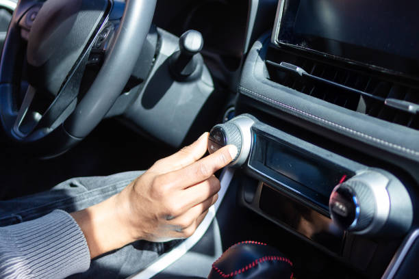 Person adjusting the volume and audio settings in a modern car