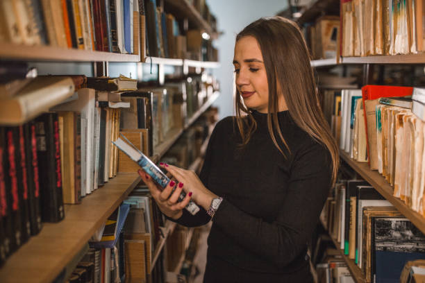 istock Woman holds a book in her hands and decides whether to read it 2202830323
