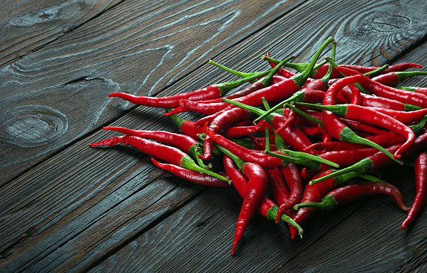 istock red hot chili peppers on a wooden table. 2202830819