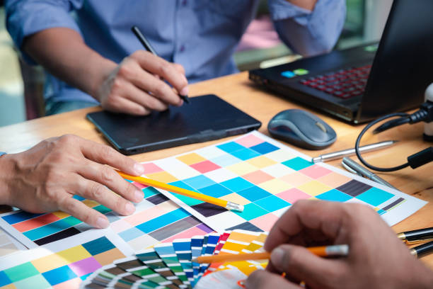istock Interior designer chooses a color chart for home design. Graphic designers working on color chart at modern office. 2202832035