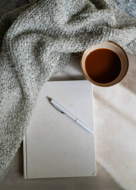 istock Planner notebook and cup of coffee on shadows background 2202832503