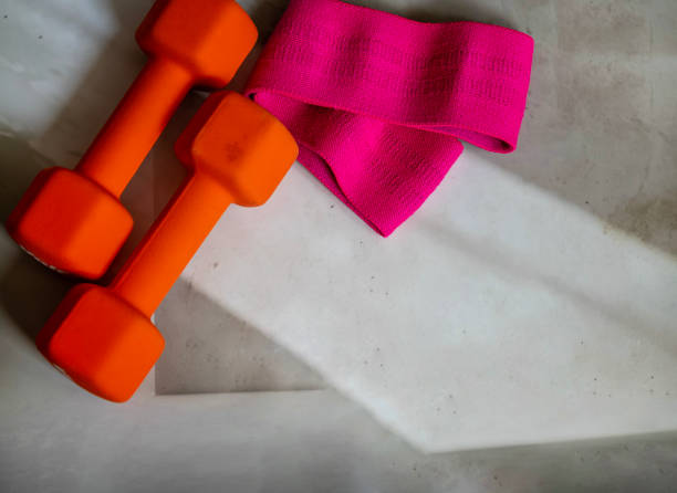 istock Dumbbells and elastic bands on shadows background 2202832796