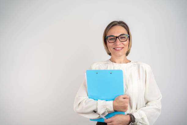 istock Smiling businesswoman with clipboard looking at camera 2202833323