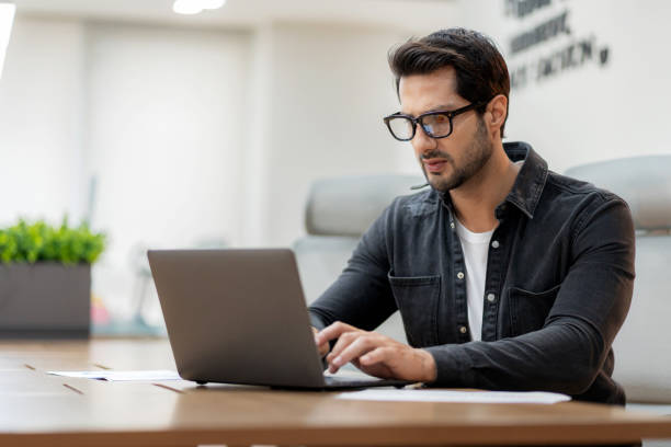 istock Casual business strategist analyzing market trends on a computer in a modern co-working space. A natural and inspiring work environment fostering creativity, planning, and innovation. Entrepreneurial mindset, teamwork, and success in a corporate setting. 2202836205