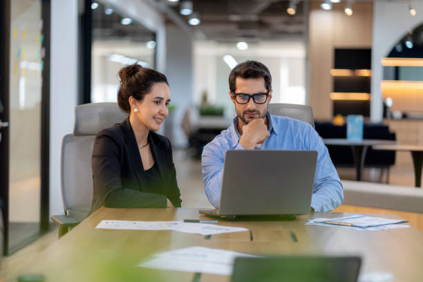 istock Businessman presenting marketing data and work plan analysis to businesswoman executive in modern office for strategic decision-making and future business development. 2202836247