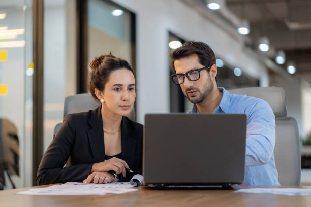 istock Future business planning with data-driven insights. A male project leader works with a diverse female team in a high-tech office, discussing finance, strategy, and innovation. Corporate leadership, collaboration, and digital transformation in action. 2202836526