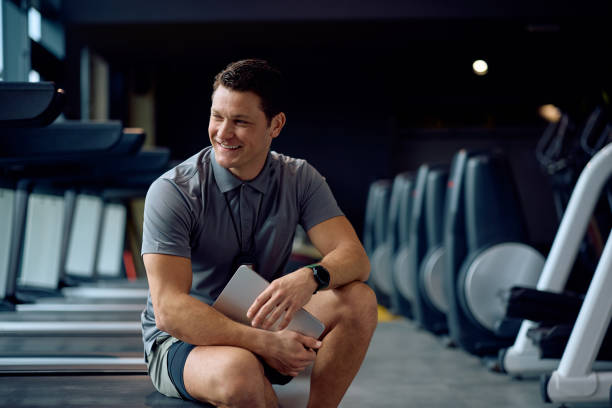 istock Happy personal trainer working in a gym and looking away. 2202837386
