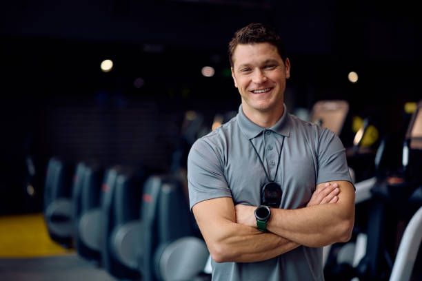 istock Confident personal trainer with crossed arms in a gym looking at camera. 2202837416