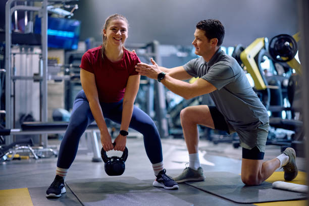 istock Happy athlete exercising with kettlebell while having sports training with her personal coach at health club. 2202837716