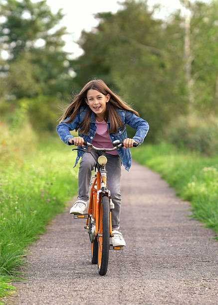 istock active cheerful girl is riding a bicycle in spring park 2202839267