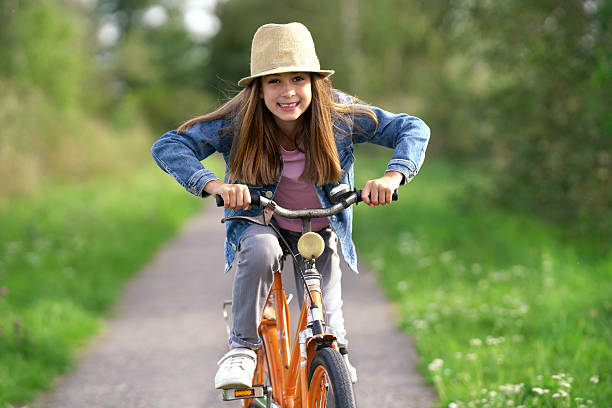 happy funny girl with her bicycle in spring season