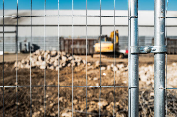 Shallow focus of a secure metal fence seen in the vicinity of construction works on a British industrial estate. stock photo