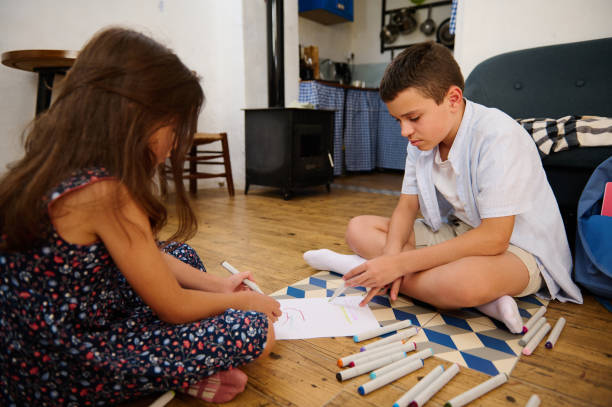 istock Children Drawing Together on the Floor 2202843429
