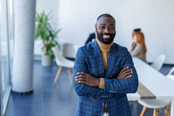 istock Confident businessman smiling with arms crossed in modern office 2202844806