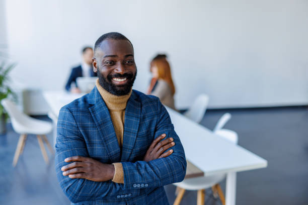 istock Confident businessman smiling with arms crossed in modern office 2202844810