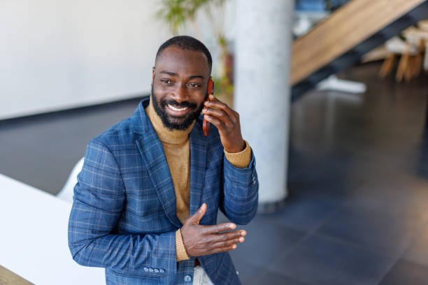 istock Smiling businessman talking on the phone in a modern office 2202844845