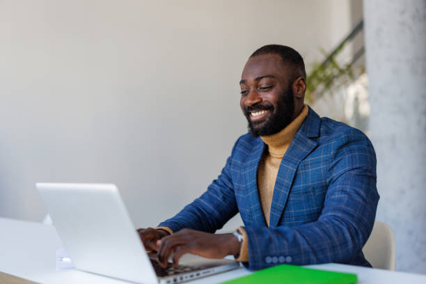 istock Smiling businessman working on laptop in modern office 2202844861