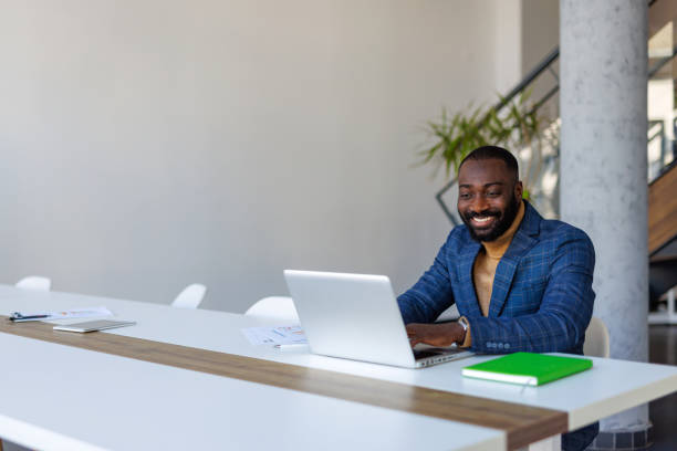 istock Smiling businessman working on laptop in modern office 2202844867